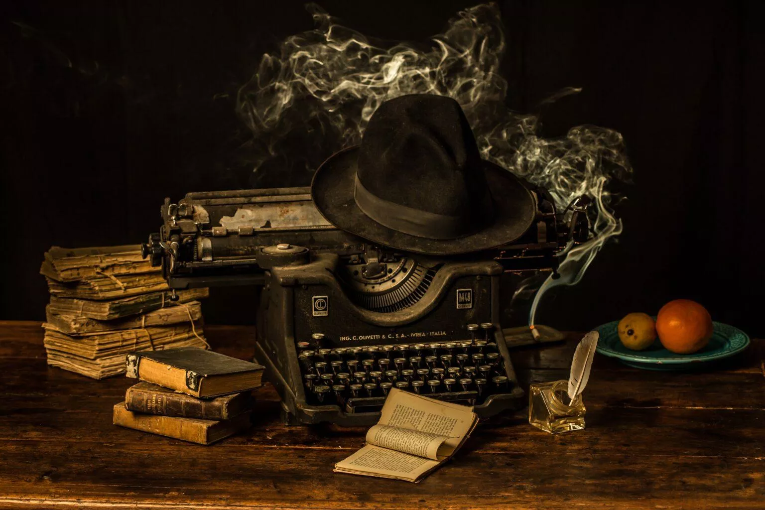 typing-machine-fedora-hat-old-books-wooden-table-1536x1024